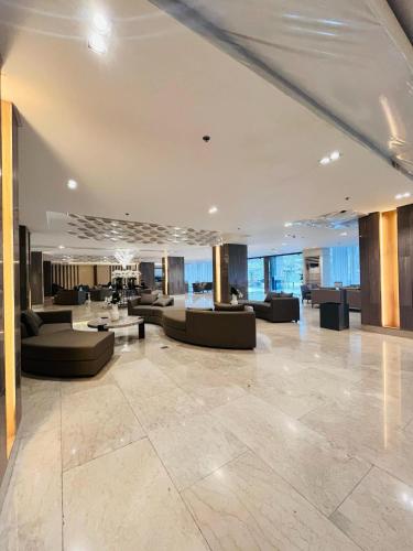 a lobby with couches and tables in a building at Modern City Escape Near MOA and Airport with Balcony and Fast WiFi in Manila
