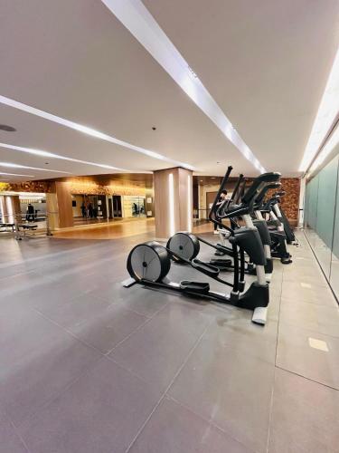 a gym with treadmills and ellipticals in a building at Modern City Escape Near MOA and Airport with Balcony and Fast WiFi in Manila