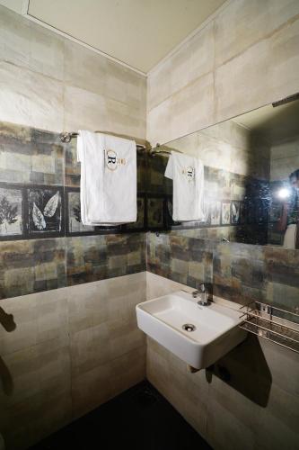 a bathroom with a sink and a mirror and towels at Hotel Royce Executive Near US Consulate, Bandra Kurla Complex in Mumbai