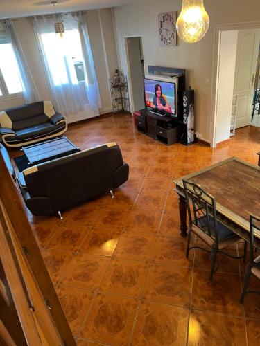 un salon avec un canapé et une télévision dans l'établissement Maison, Proxi Proximité campus, INSA doua centre Villeurbanne, à Villeurbanne