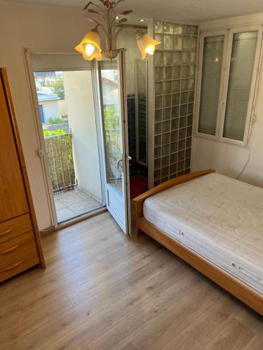une chambre avec un lit et une porte coulissante en verre dans l'établissement Maison, Proxi Proximité campus, INSA doua centre Villeurbanne, à Villeurbanne