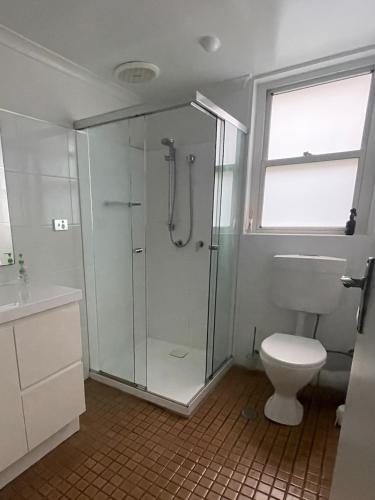 a bathroom with a shower and a toilet at Dutchies Beachside Retreat in Nelson Bay