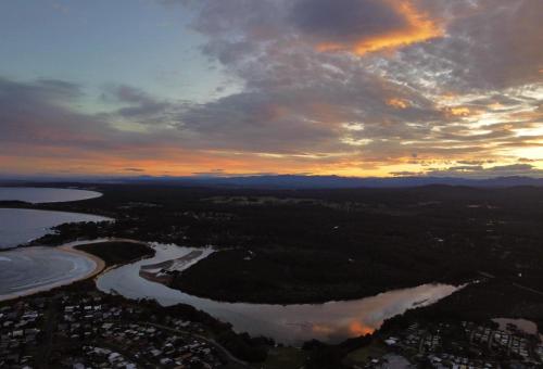 an aerial view of a river at sunset at Just Beachy in Tomakin