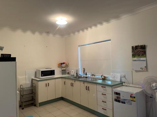 a kitchen with a sink and a microwave at Just Beachy in Tomakin