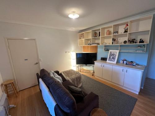 a living room with a couch and a television at Just Beachy in Tomakin