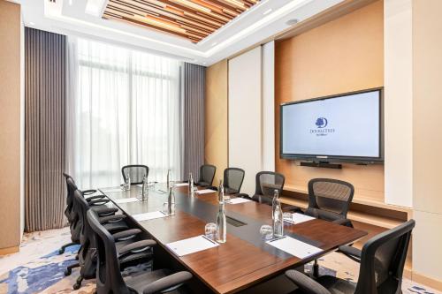 a conference room with a long table and chairs and a flat screen tv at DoubleTree by Hilton Vientiane in Vientiane