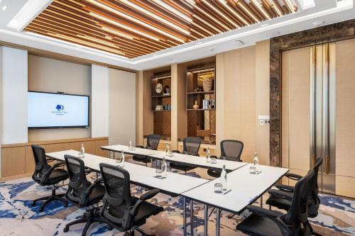 a conference room with tables and chairs and a projection screen at DoubleTree by Hilton Vientiane in Vientiane