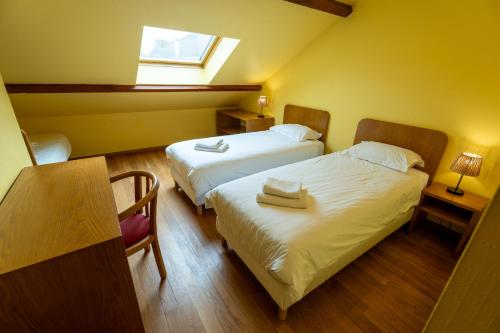 a hotel room with two beds and a window at La Bullote - Gîtes - Paris Roissy CDG in Villeneuve-sous-Dammartin