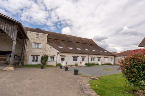 a large brick building with a large roof at La Bullote - Gîtes - Paris Roissy CDG in Villeneuve-sous-Dammartin