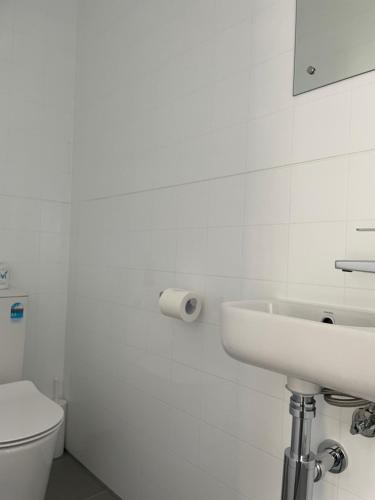 a white bathroom with a sink and a toilet at Mataki Motel in Murchison