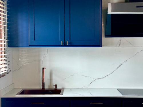a kitchen with blue cabinets and a sink at Brown Brick Thonglor - Blue Blueberry Room in Klong Toi