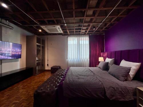 a bedroom with a large bed and a purple wall at Brown Brick Thonglor - Blue Blueberry Room in Klong Toi