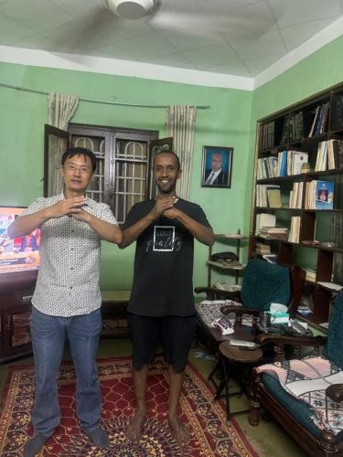 two men standing in a living room with their arms crossed at SEO House in Aswan