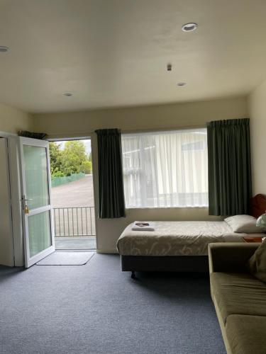 a bedroom with a bed and a sliding glass door at Mataki Motel in Murchison
