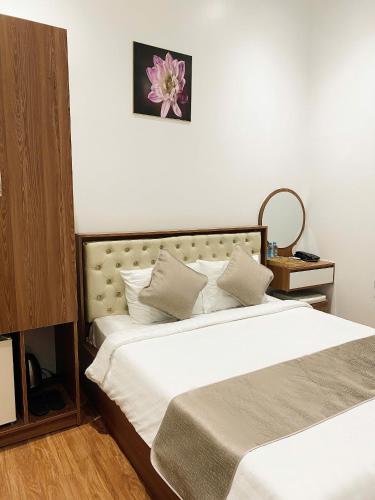 a bedroom with two beds and a flower on the wall at Gaki Hotel in Hue