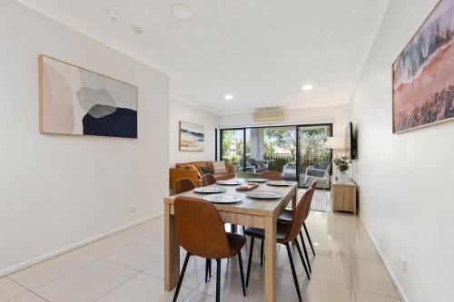a dining room and living room with a table and chairs at Home-like Garden Apartment in Brisbane