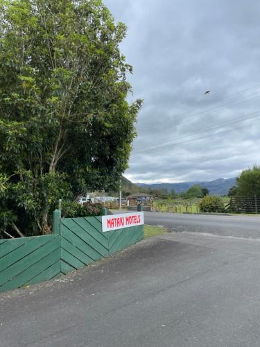 a sign on a fence next to a road at Mataki Motel in Murchison