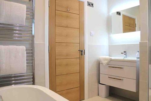Un baño con lavabo, inodoro y espejo. en Nyth Glan y Môr, Modern Luxury Lodge with Hot Tub, en Pembrokeshire
