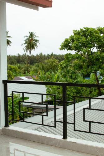 a balcony with a bench on top of a building at Thooru stay in Kelaa