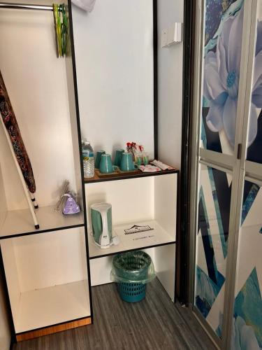 a room with white shelves with blue pots on them at Villa Wanie Cottage in Setiu