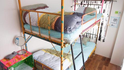 a couple of bunk beds in a room at Kamagasaki University of the Arts Cafe Garden Guest House aka Cocoroom in Osaka