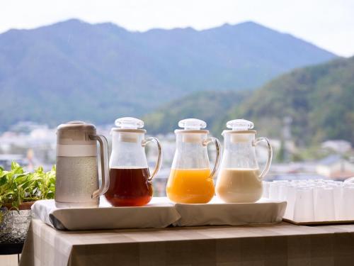 three bottles of honey and juice sitting on a table at Hotel Areaone Wadayama in Asago