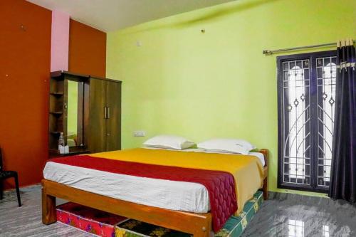 a bedroom with a bed and a large window at Lakeside Home Stay Villa in Yelagiri