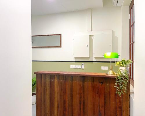 a kitchen with a wooden counter with a green lamp at INN Lebuh Melayu in George Town