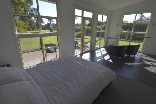 a bedroom with a bed and a large window at River Walk B&B in Robigana