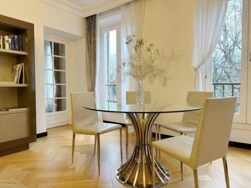 une salle à manger avec une table et des chaises en verre dans l'établissement Elégant 4 pièces au coeur du Paris artiste, à Paris