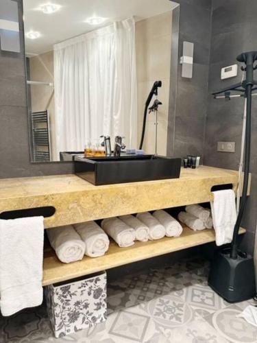 une salle de bain avec un lavabo et une étagère avec des serviettes dans l'établissement Elégant 4 pièces au coeur du Paris artiste, à Paris