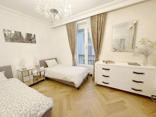 une chambre avec deux lits et une commode et une fenêtre dans l'établissement Elégant 4 pièces au coeur du Paris artiste, à Paris