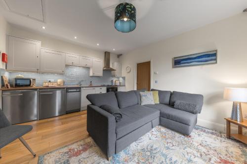 a living room with a couch and a kitchen at Grizedale View in Coniston