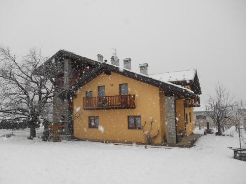 a house covered in snow in a yard at La Vigne de Papagran in Aosta
