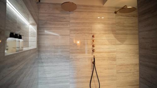 a bathroom with a shower with wooden walls at B&B Het Nagtegaaltje in Collendoorn