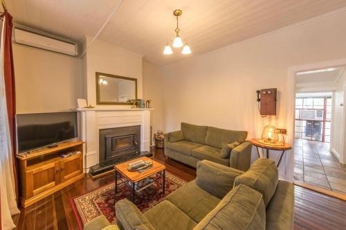 a living room with a couch and a fireplace at Telegraph Cottage in Greenock