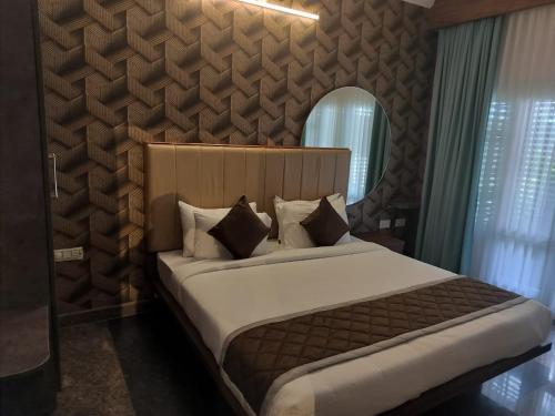 KolārOlivia Resort and Spa a unit of Falgu Resorts Pvt Ltd的带一张大床和一面镜子的卧室