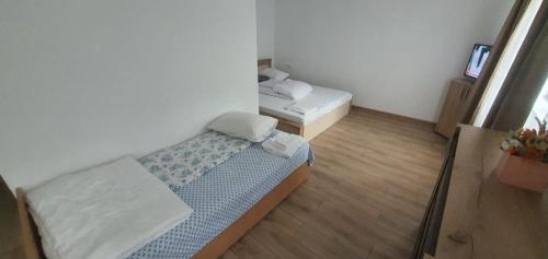 ein kleines Zimmer mit einem Bett und einem Fernseher in der Unterkunft Casa Vida in Luncasprie