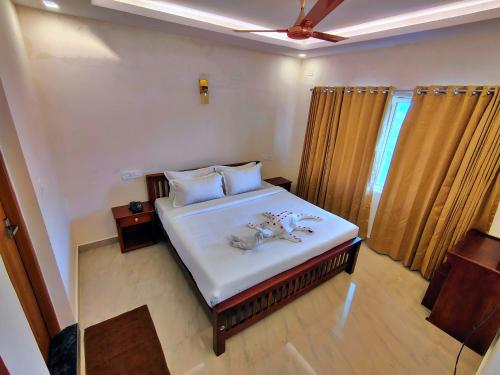 a bedroom with a bed with two animals on it at The Autumn by Maat Hotels in Vagamon