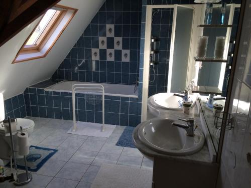 a bathroom with a sink and a tub and a toilet at Gite Campagne-Bergues in Socx