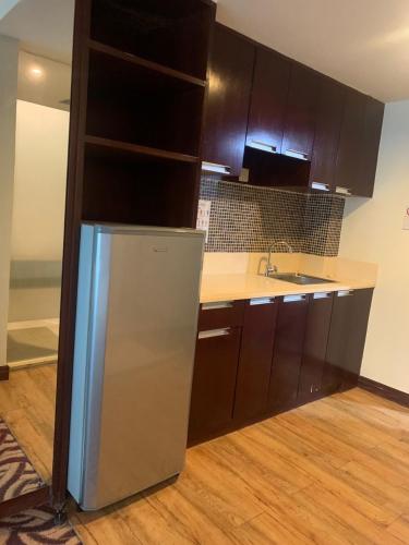 a kitchen with a refrigerator and a sink at FAINA Homestay SCSP Minggarden Resident Kota Kinabalu in Kota Kinabalu