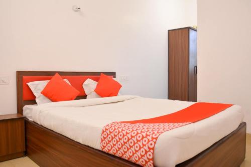 a bedroom with a bed with orange and white pillows at Super Collection O Sayhallo Kanchan in Bhubaneshwar