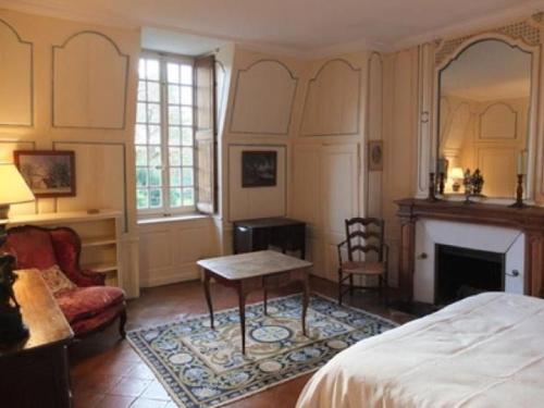 a bedroom with a bed and a fireplace and a table at Gîte historique au château de charme proche du Mans - FR-1-410-453 in Saint Pavace