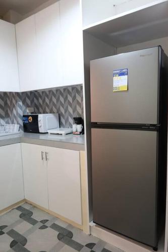a kitchen with a refrigerator in the corner of a kitchen at Skyline Home Antipolo in Antipolo