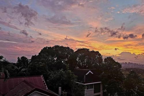a sunset over a city with trees and a building at Skyline Home Antipolo in Antipolo