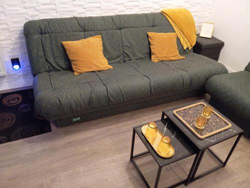 a living room with a green couch and a table at Black Diamond Lux - deluxe riverside apartment in Senta