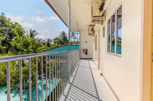 a balcony with a view of a swimming pool at Thooru stay in Kelaa