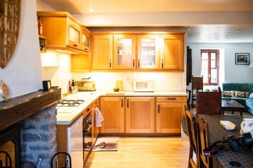 une cuisine avec des armoires en bois et un four à plaques de cuisson dans l'établissement Le Gîte de la Source BOUSSAGUES, à La Tour-sur-Orb