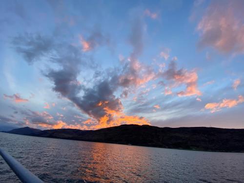 a view of a sunset from a boat on a lake at Torlinnhe in Fort William