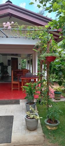 a patio with potted plants and a table and bench at Sigiriya Moonlight Home in Sigiriya